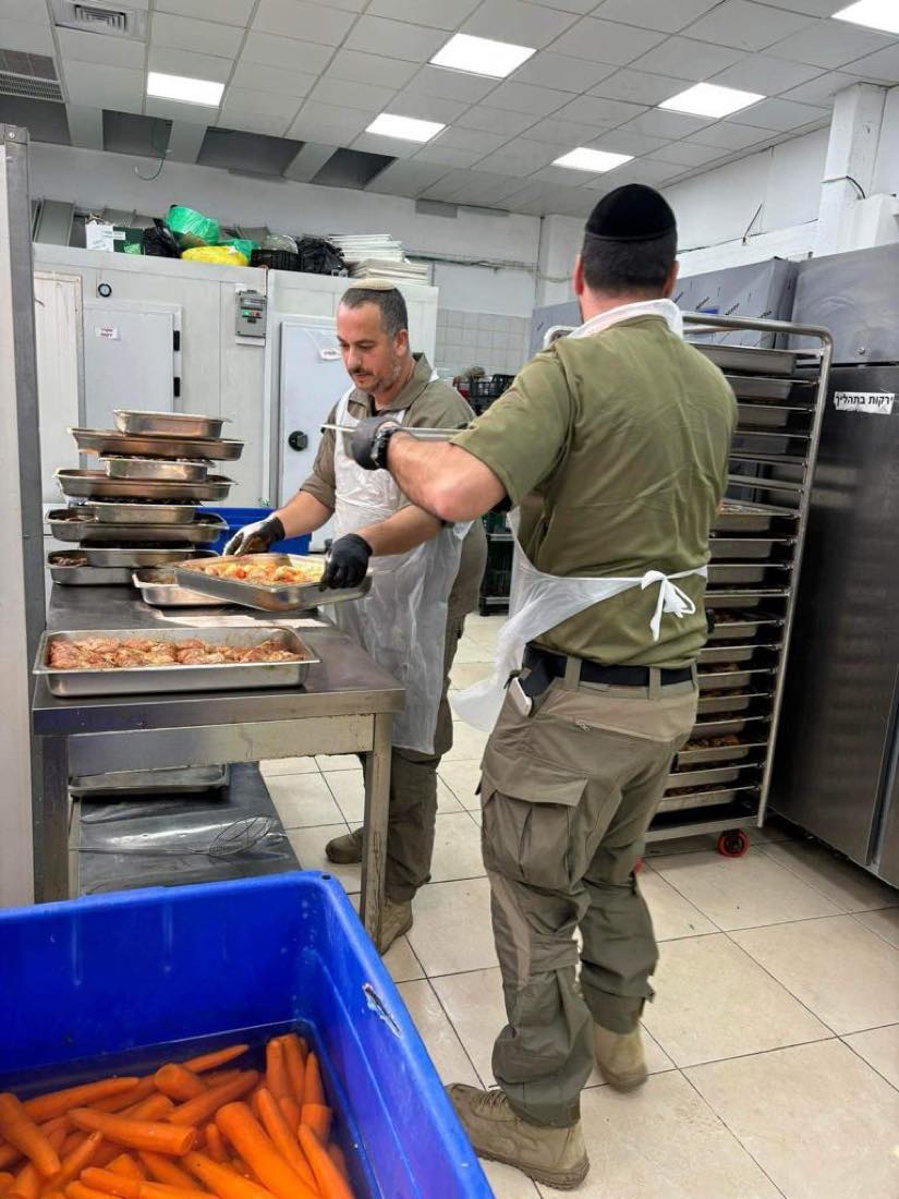 מתנדבים עובדים יחד במטבח בין תבניות אוכל