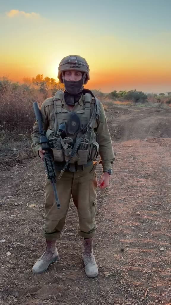 לוחם צה״ל עומד בשטח בשעת שקיעה